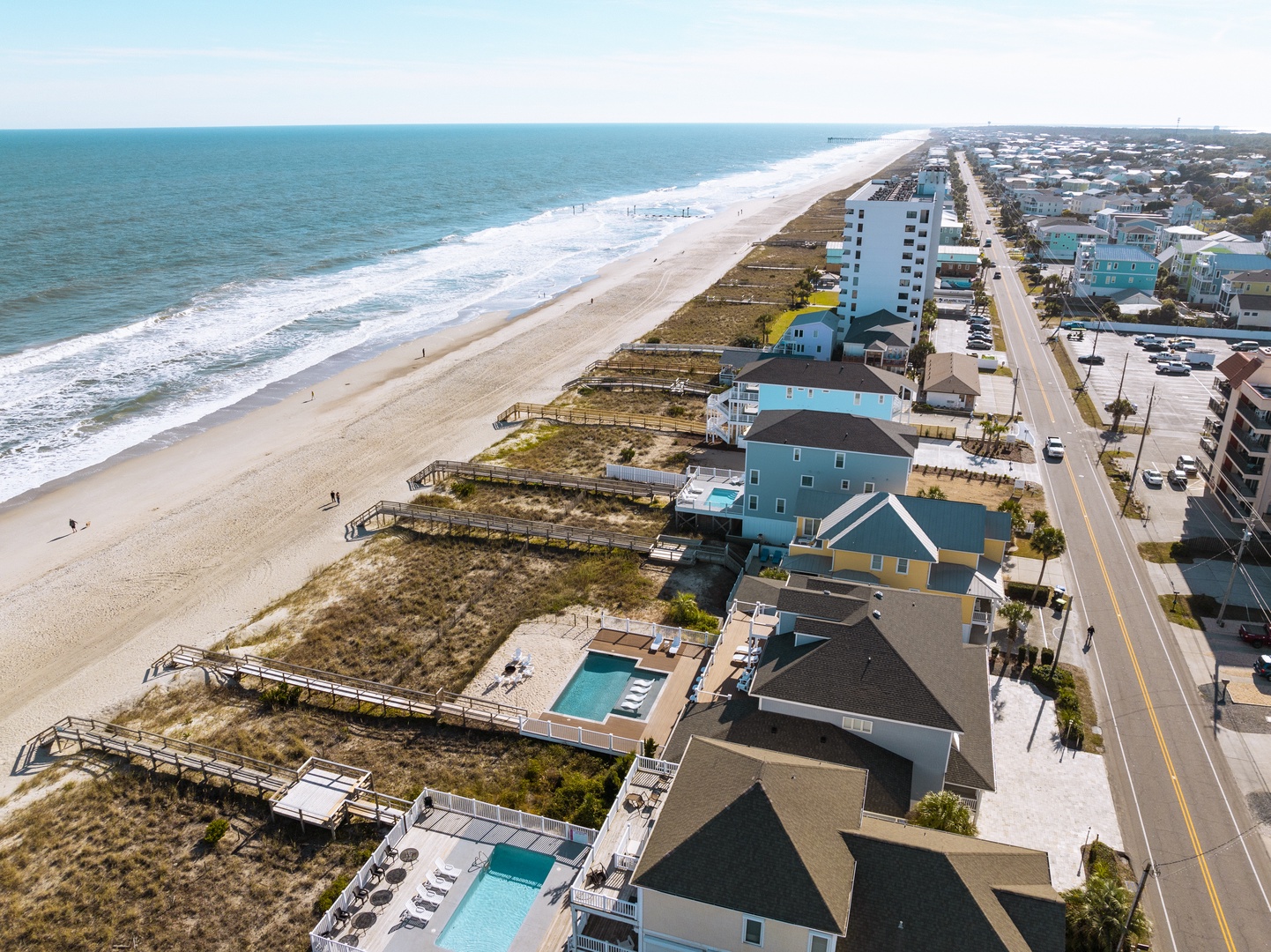 Stunning beachfront community with pristine sandy shores and coastal homes stretching along the shoreline.