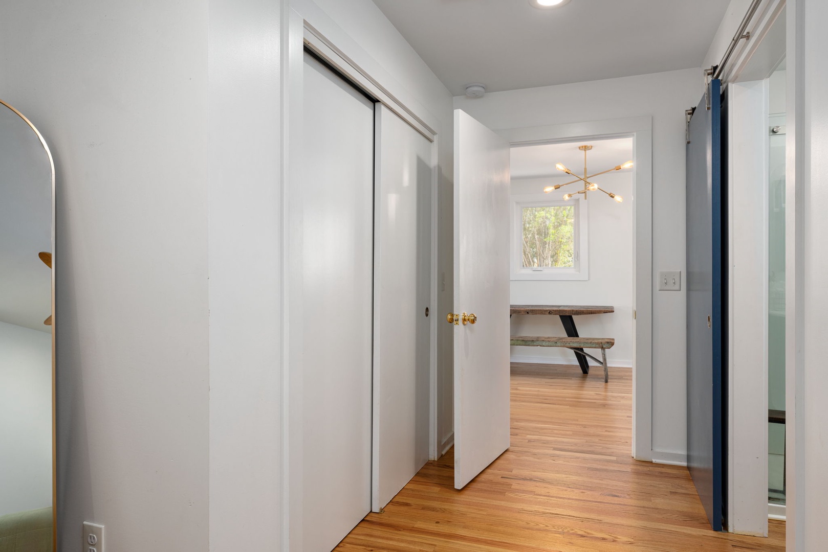 Your bright hallway connects seamlessly to a dining area with warm wood floors and stylish lighting fixtures.