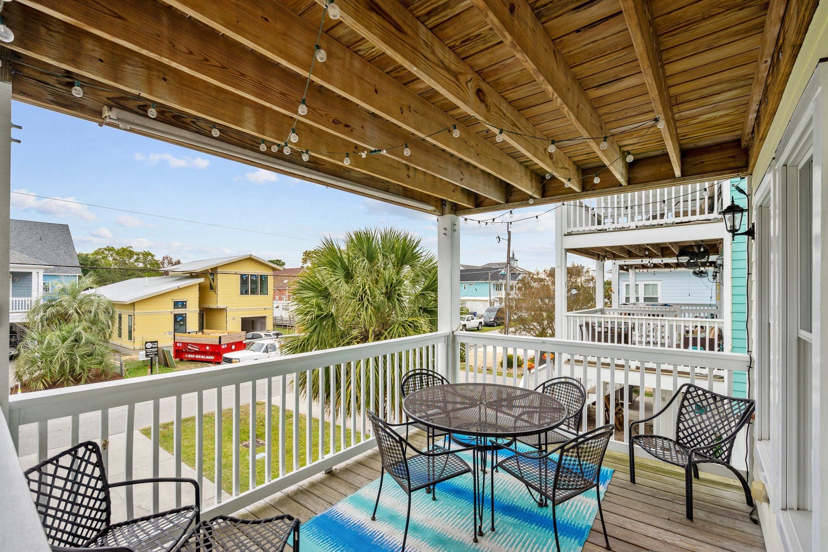 Gather around your private dining table on this covered deck, where palm trees and coastal charm create the perfect backdrop for meals together.