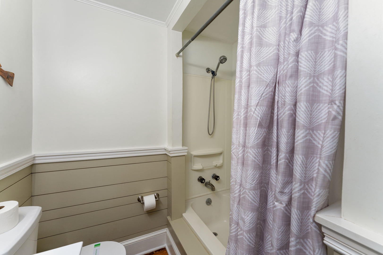 Refresh in your private bathroom featuring a full tub-shower combo with charming patterned curtain and clean, modern finishes.