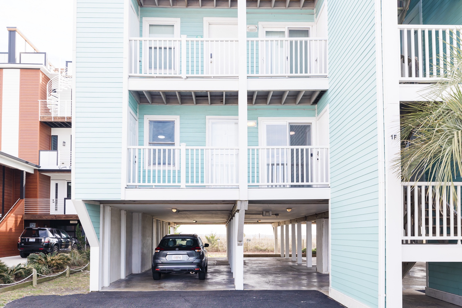 Modern three-story beach house featuring elevated design with convenient ground-level parking and private balconies on each floor.