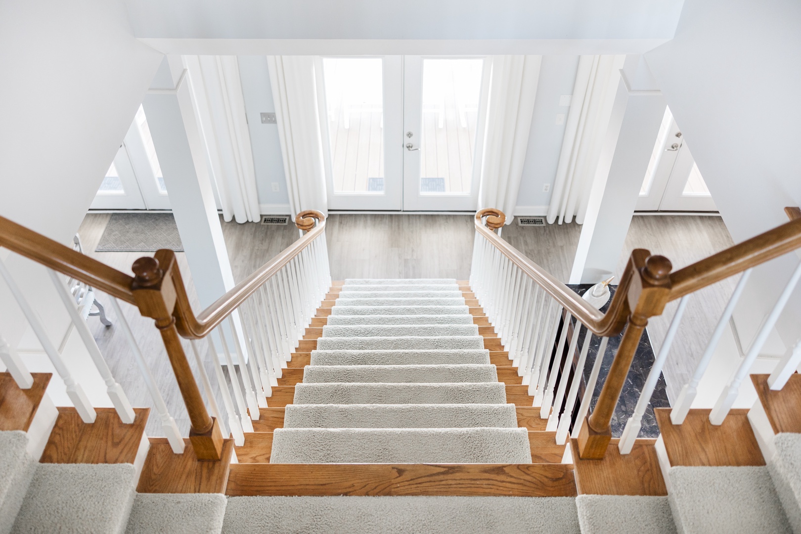 Ascend these elegant hardwood stairs with plush carpet runners to discover your comfortable retreat above.
