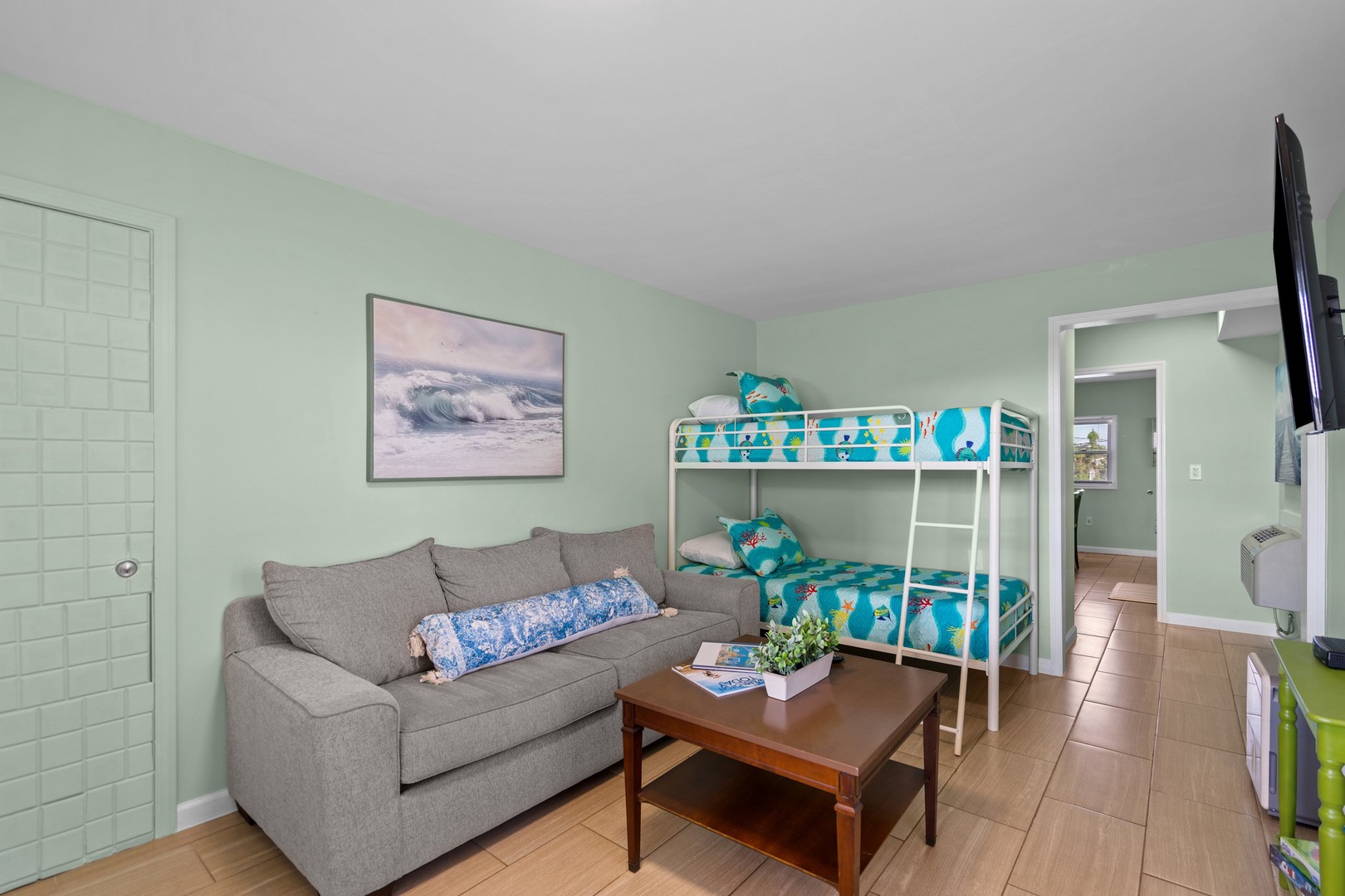 Unwind on your comfortable sofa while the kids enjoy their fun bunk beds in this cozy space.