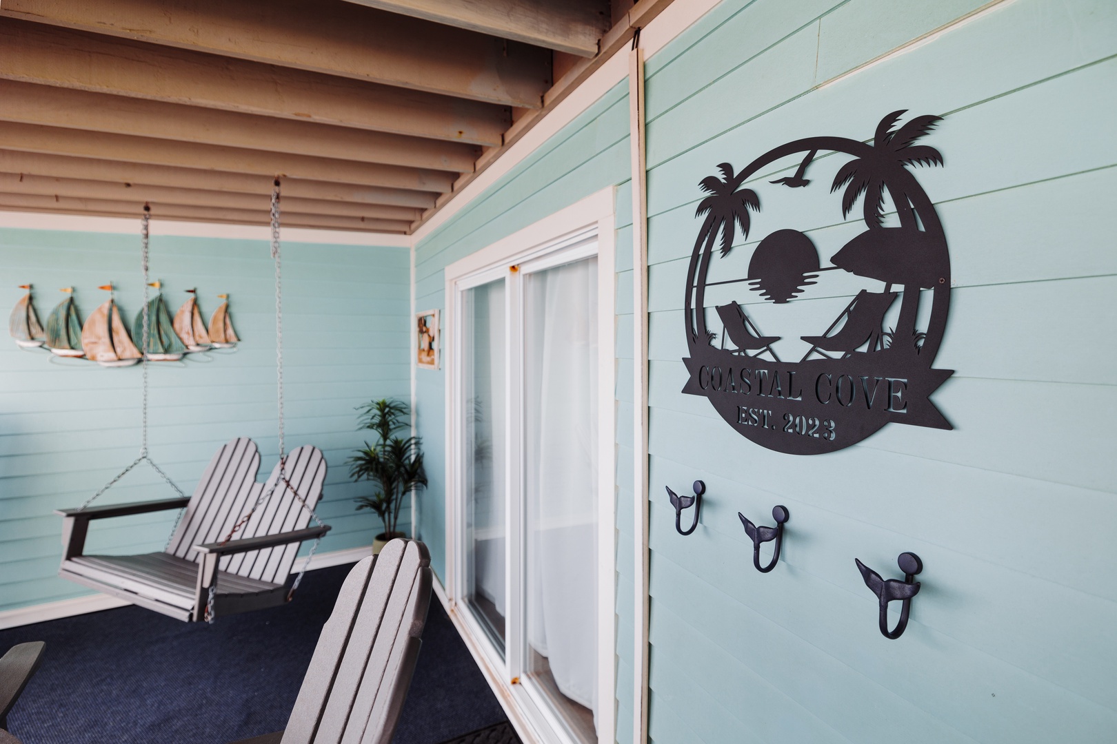 Your private porch invites quiet mornings in coastal-themed comfort, complete with Adirondack chairs and charming nautical touches.