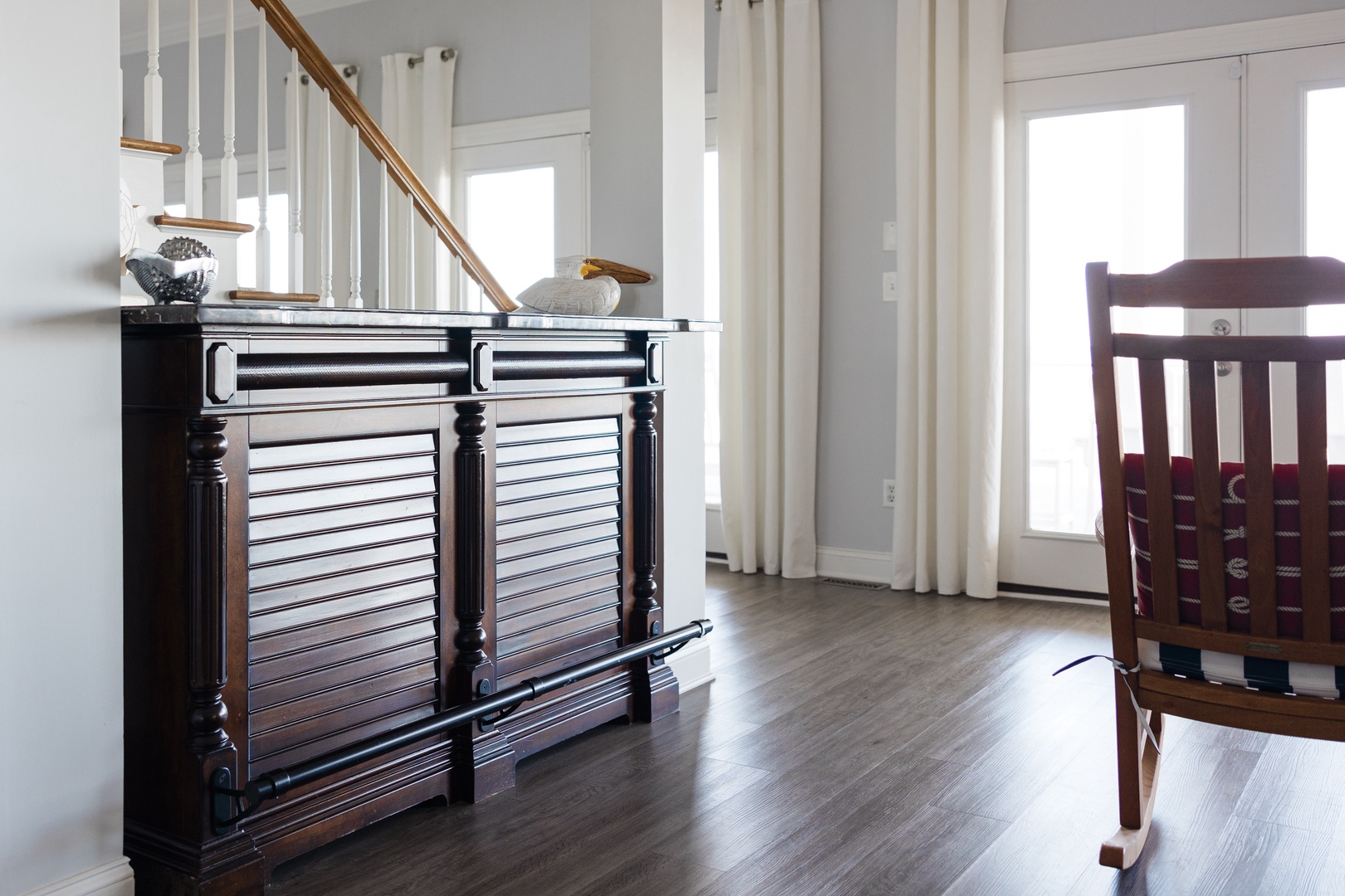 Your bright living space features rich hardwood floors and elegant furnishings, creating a warm coastal atmosphere perfect for relaxation.