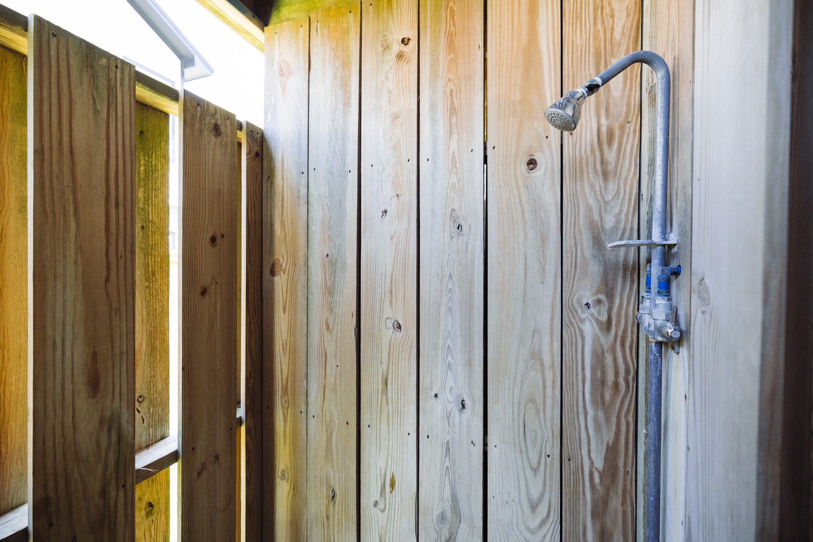 Rinse off after your beach day in this private outdoor shower, surrounded by natural wood for complete relaxation.