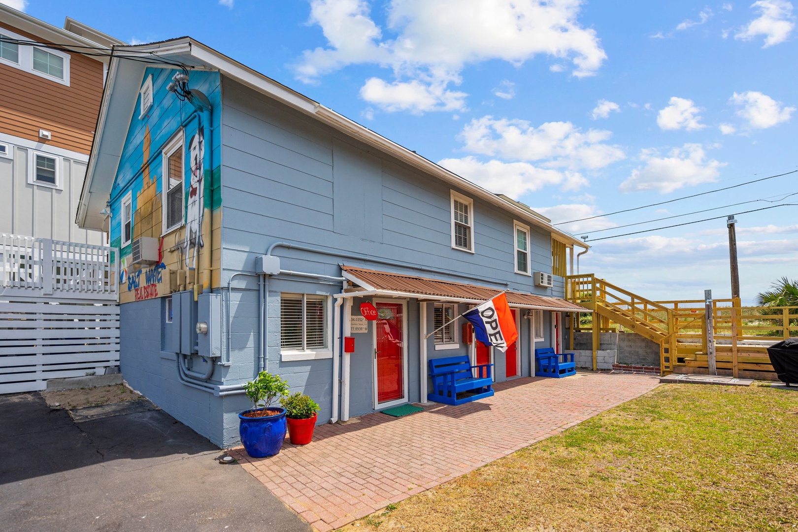 Colorful beachside property features vibrant mural artwork and nautical charm in a relaxed coastal neighborhood setting.