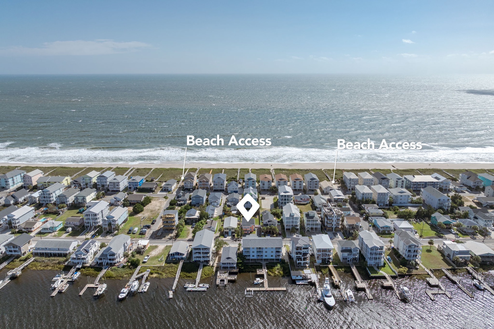 Aerial view of waterfront vacation rental community with direct beach access and marina facilities.