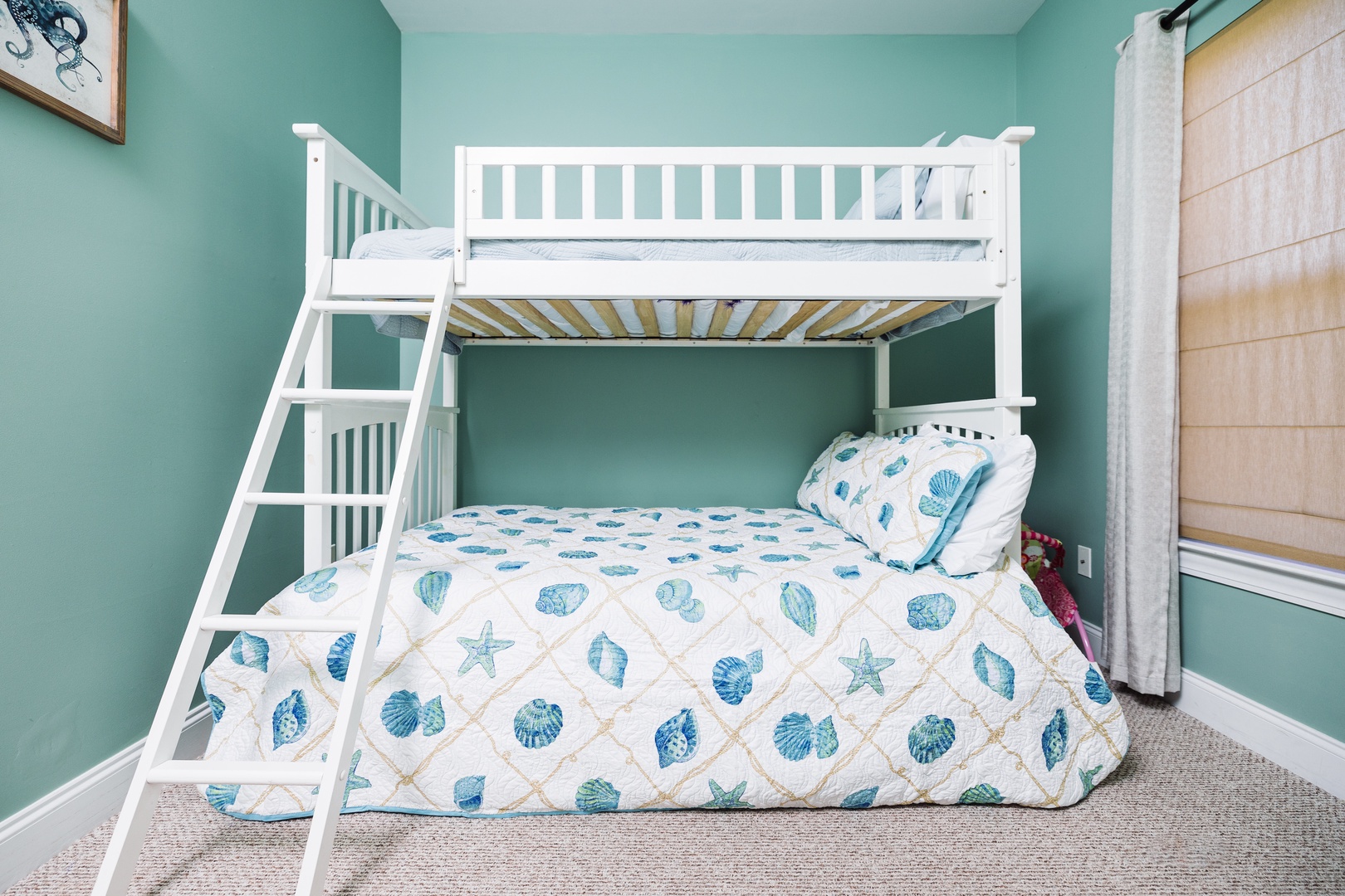 Your kids will love this charming bunk bed with ocean-themed bedding, perfect for creating bedtime adventures in this cozy retreat.