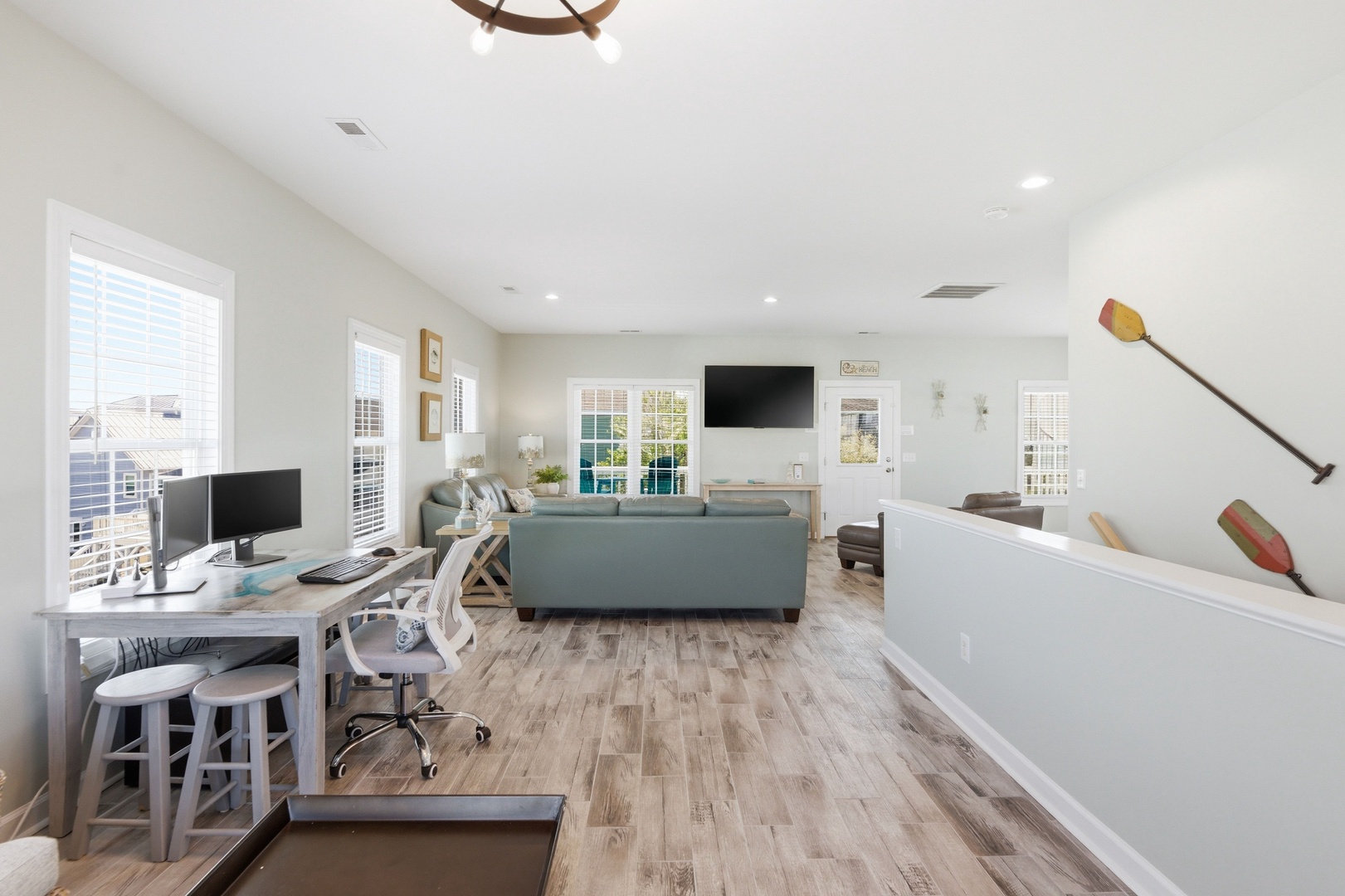 Step into your bright, open-concept living space where coastal charm meets modern comfort. Relax on plush sofas, catch up on work at the desk, or gather with loved ones in this airy retreat.