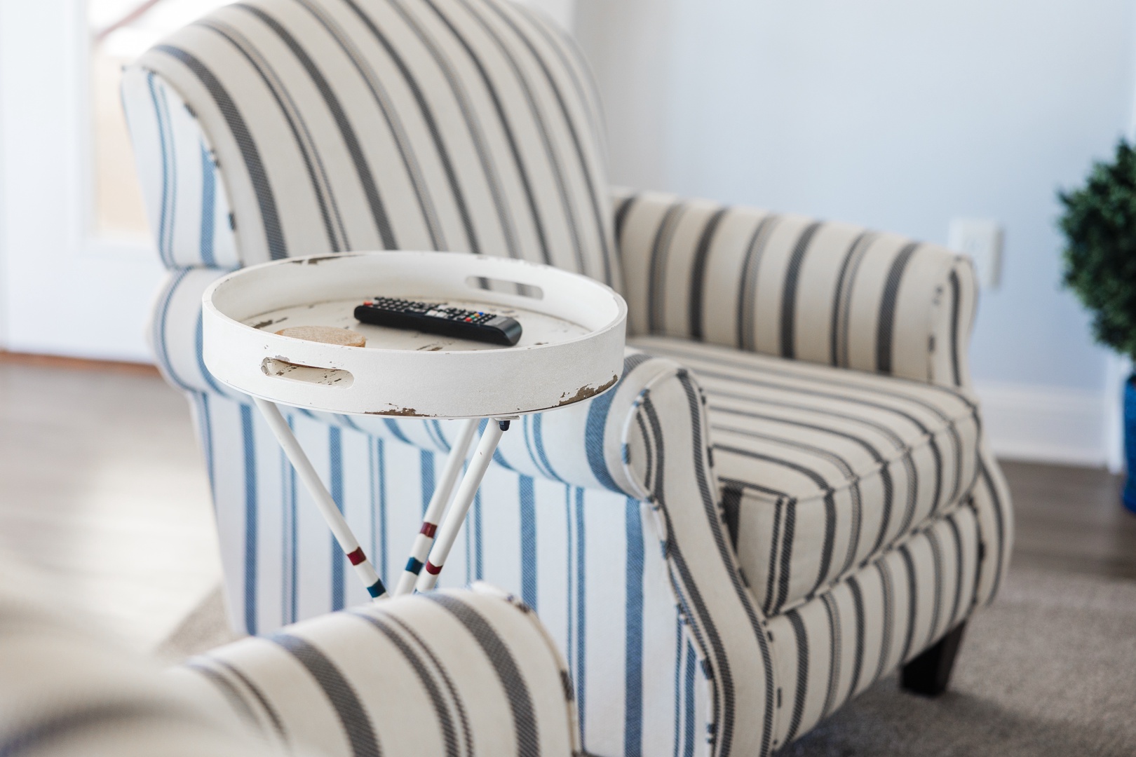 Sink into the striped armchair with your remote and unwind in this cozy living space designed for your comfort.