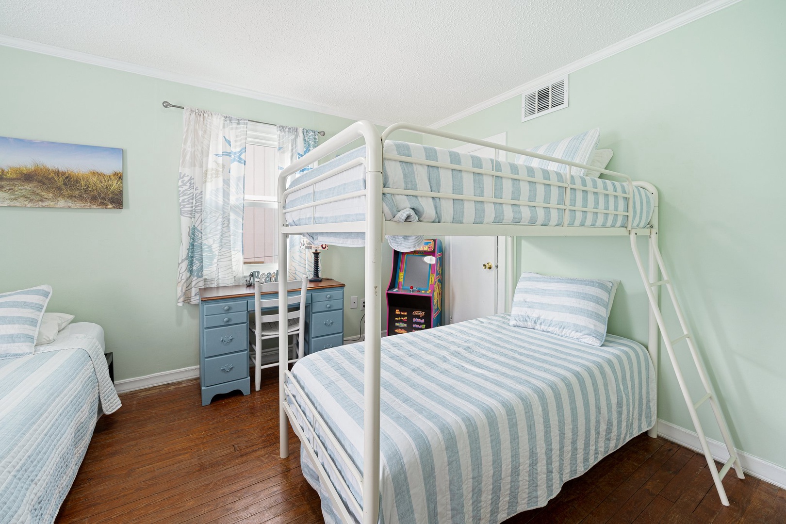 Your kids will love this coastal-themed bunk room with arcade game and extra twin bed for maximum fun and flexibility.