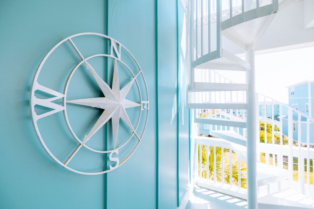 Your bright coastal retreat features nautical touches and a white spiral staircase that leads to your private outdoor balcony.