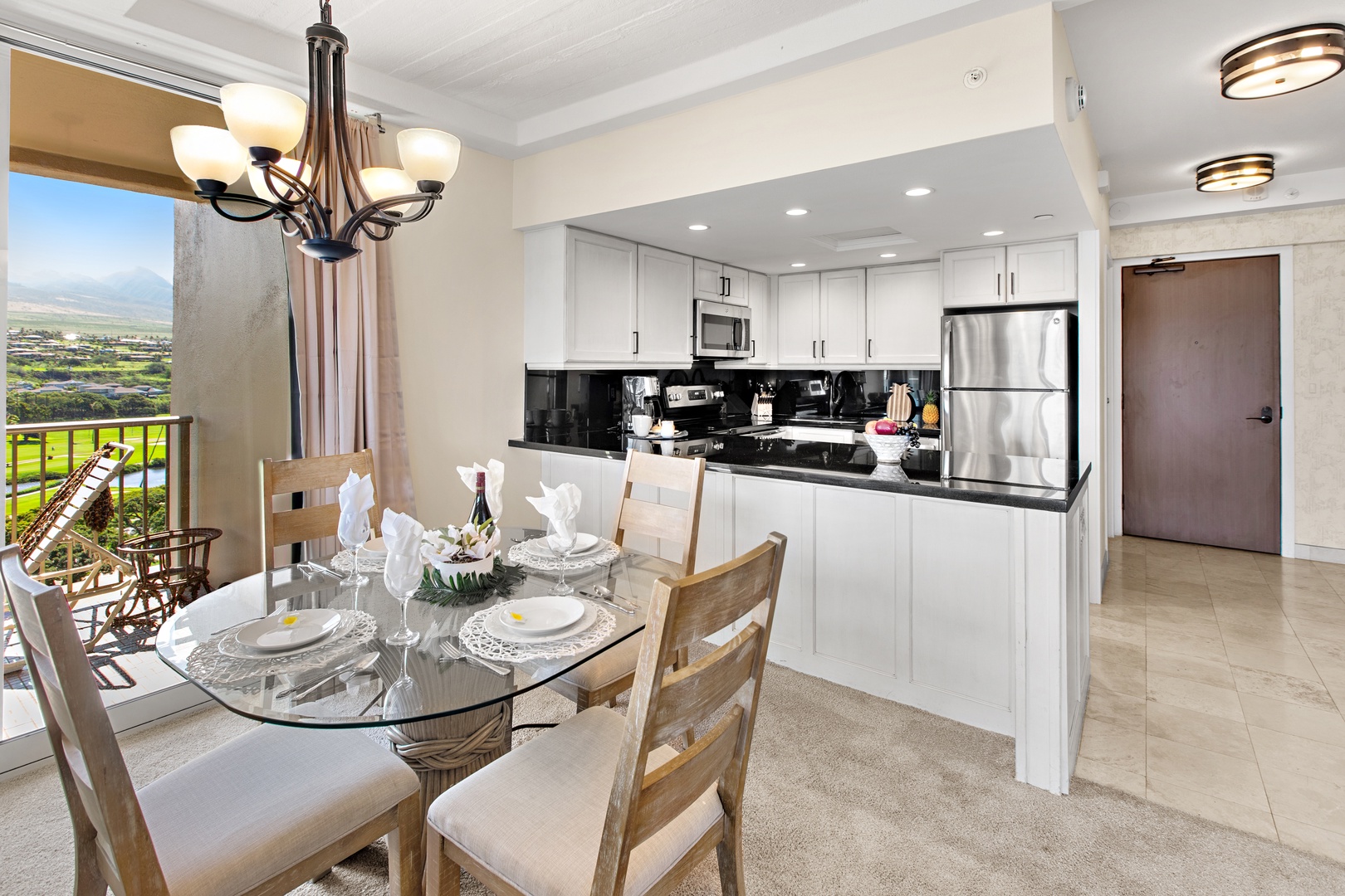Gather around your elegantly set dining table with stunning mountain and valley views through the balcony doors, while the fully equipped modern kitchen awaits your culinary creations.