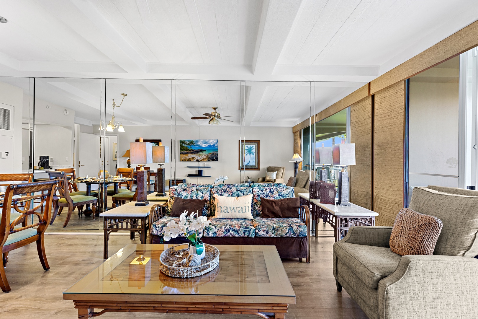 Settle into this spacious living area where tropical prints meet island comfort. Vaulted ceilings and natural light create an airy, inviting space for you to unwind after beach days.