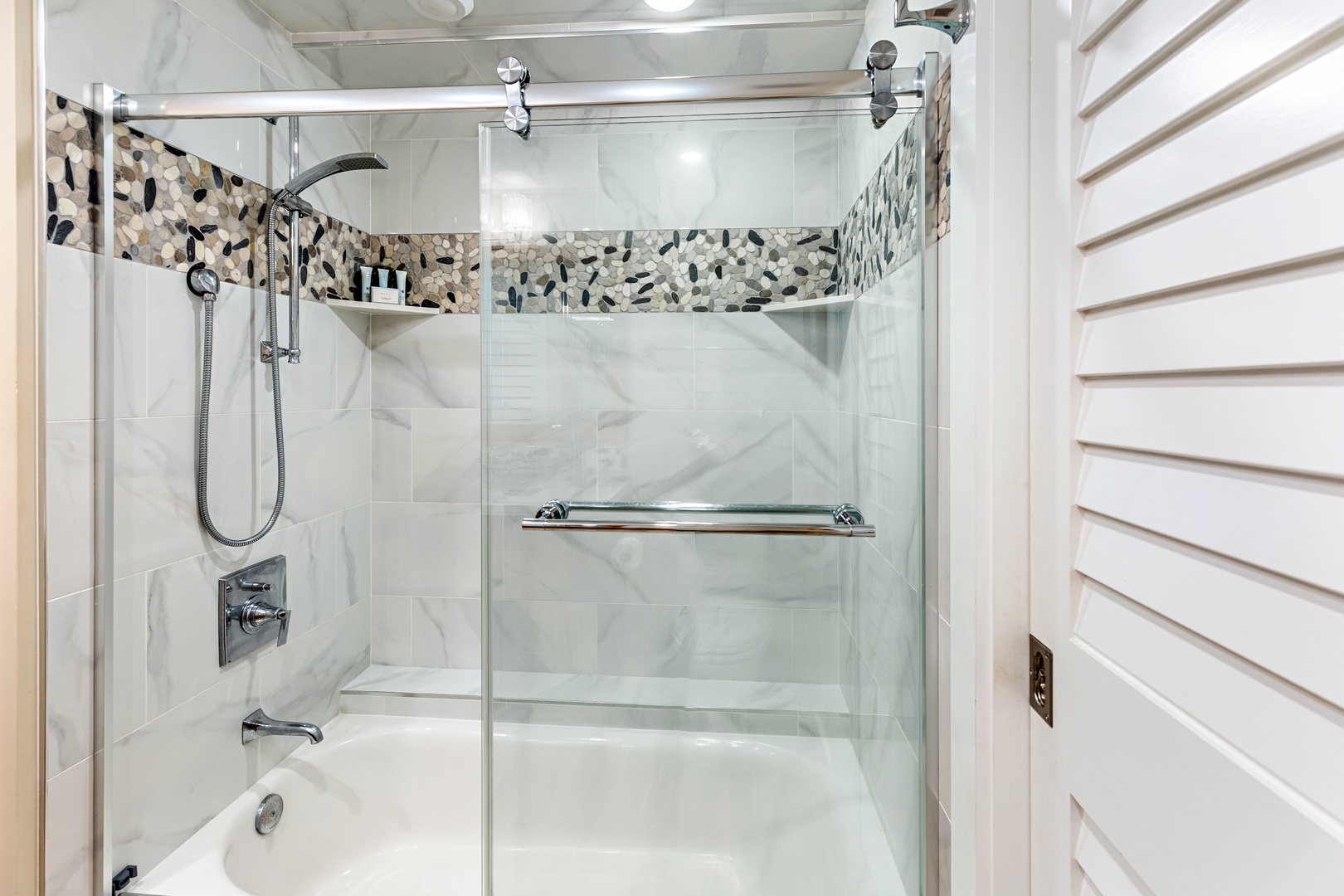 Step into your beautifully appointed bathroom featuring elegant marble-look walls and stunning mosaic tile accents that create a spa-like retreat.