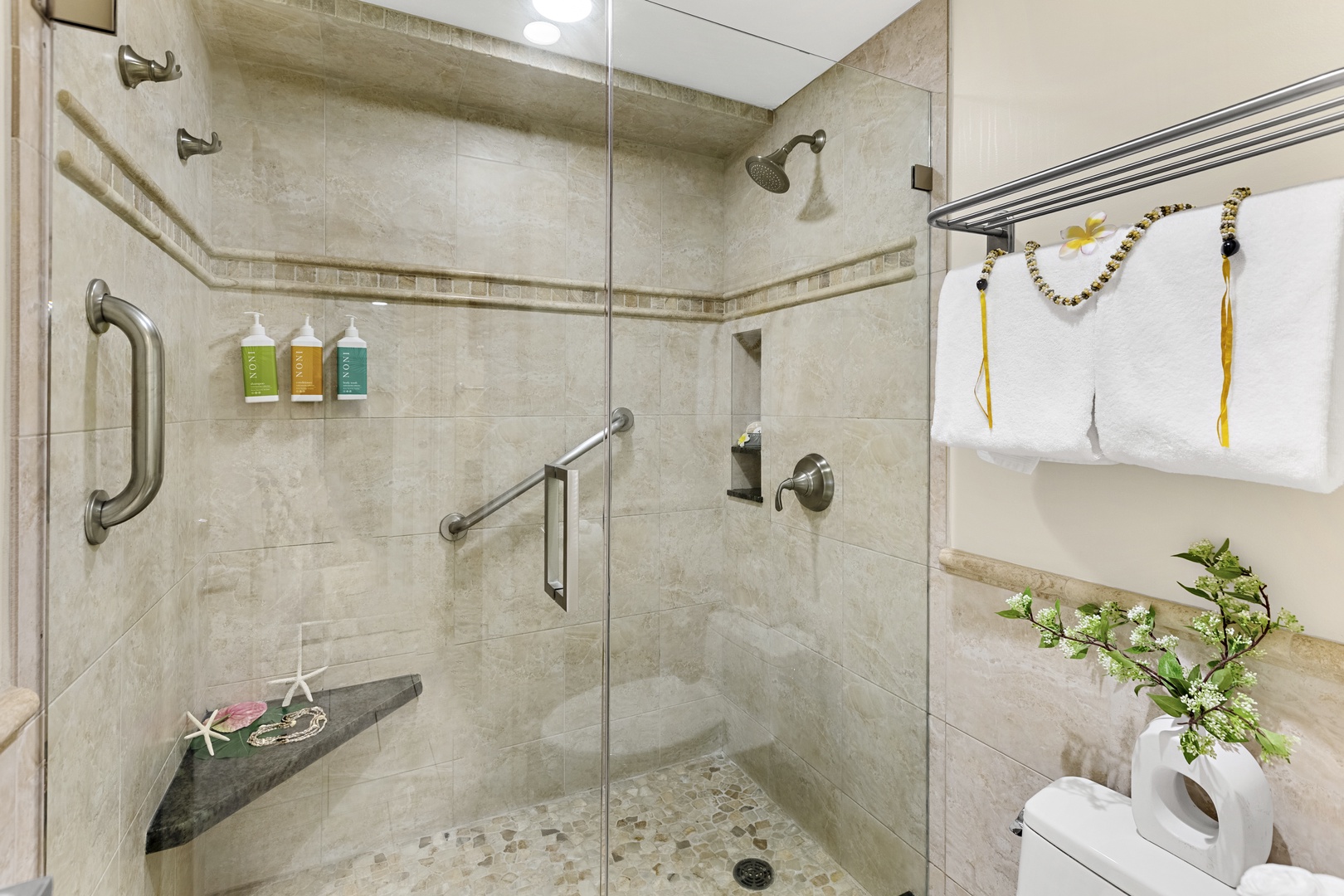 Step into your spacious walk-in shower with luxurious stone tiles, premium amenities, and thoughtful safety features for ultimate comfort.