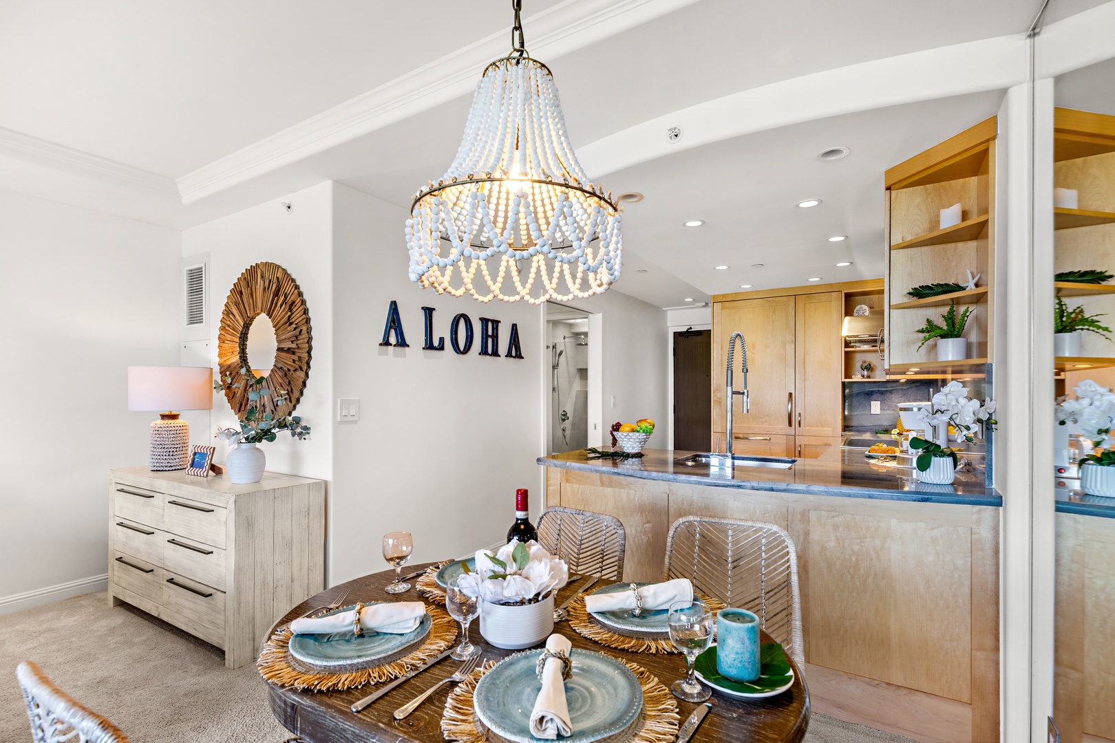 Your open dining and kitchen space welcomes you with island charm—a chandelier overhead, natural wood tones, and coastal touches that set the scene for memorable meals and relaxed gatherings.