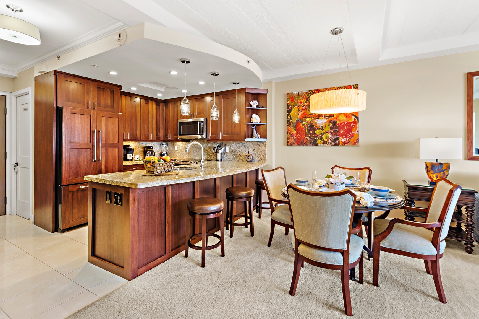 Your fully equipped kitchen and dining area blend beautifully together, with rich wood cabinetry, granite counters, and a welcoming breakfast bar—perfect for shared meals and easy mornings with coffee in hand.