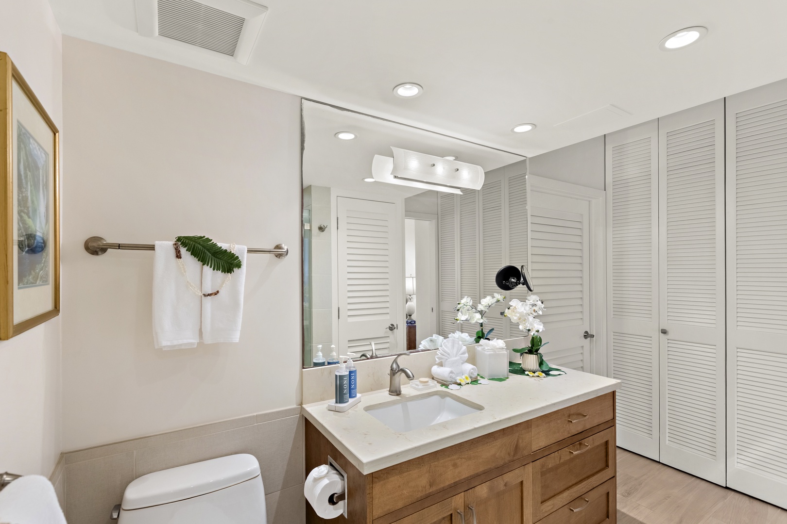 Bright bathroom with a polished vanity, large mirror, and clean, modern finishes throughout.
