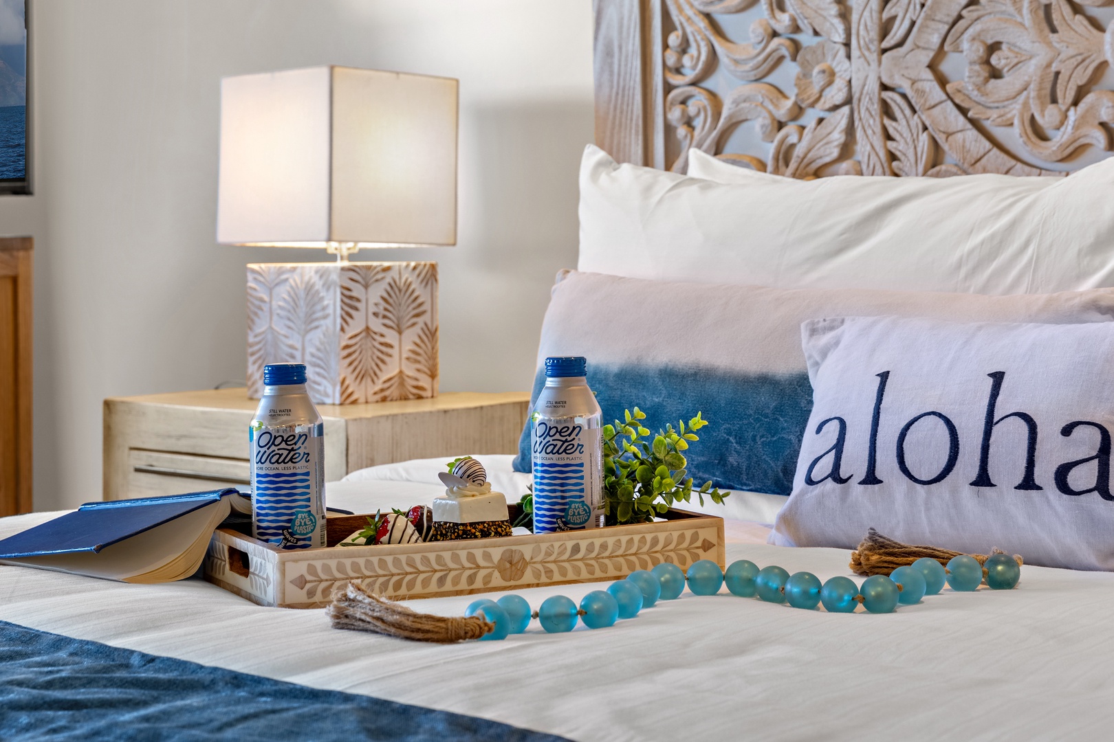 Sink into plush linens and carved island-inspired details. Your bedside welcome includes refreshing water bottles and charming coastal touches that say aloha the moment you arrive.