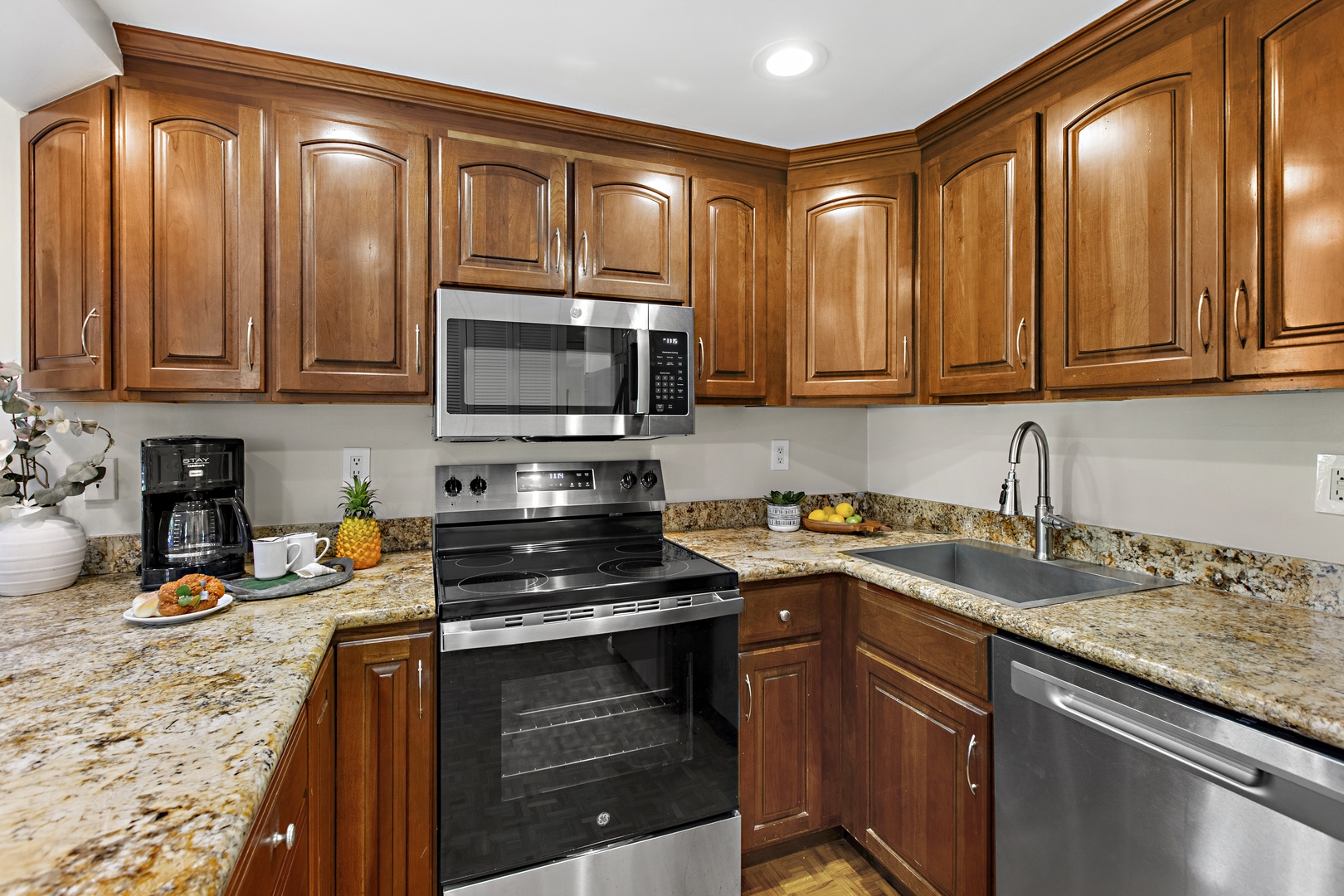 Cook memorable meals in your fully equipped kitchen featuring granite countertops, rich wood cabinets, and modern appliances.