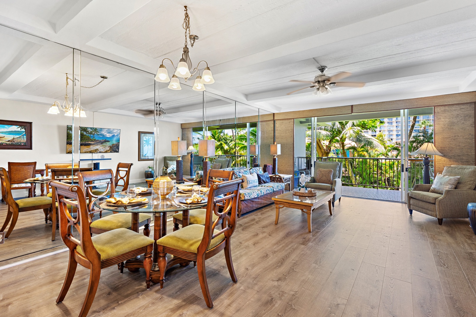Relax in this bright, open living and dining space where tropical breezes flow through sliding glass doors onto a private balcony overlooking lush palms and greenery.