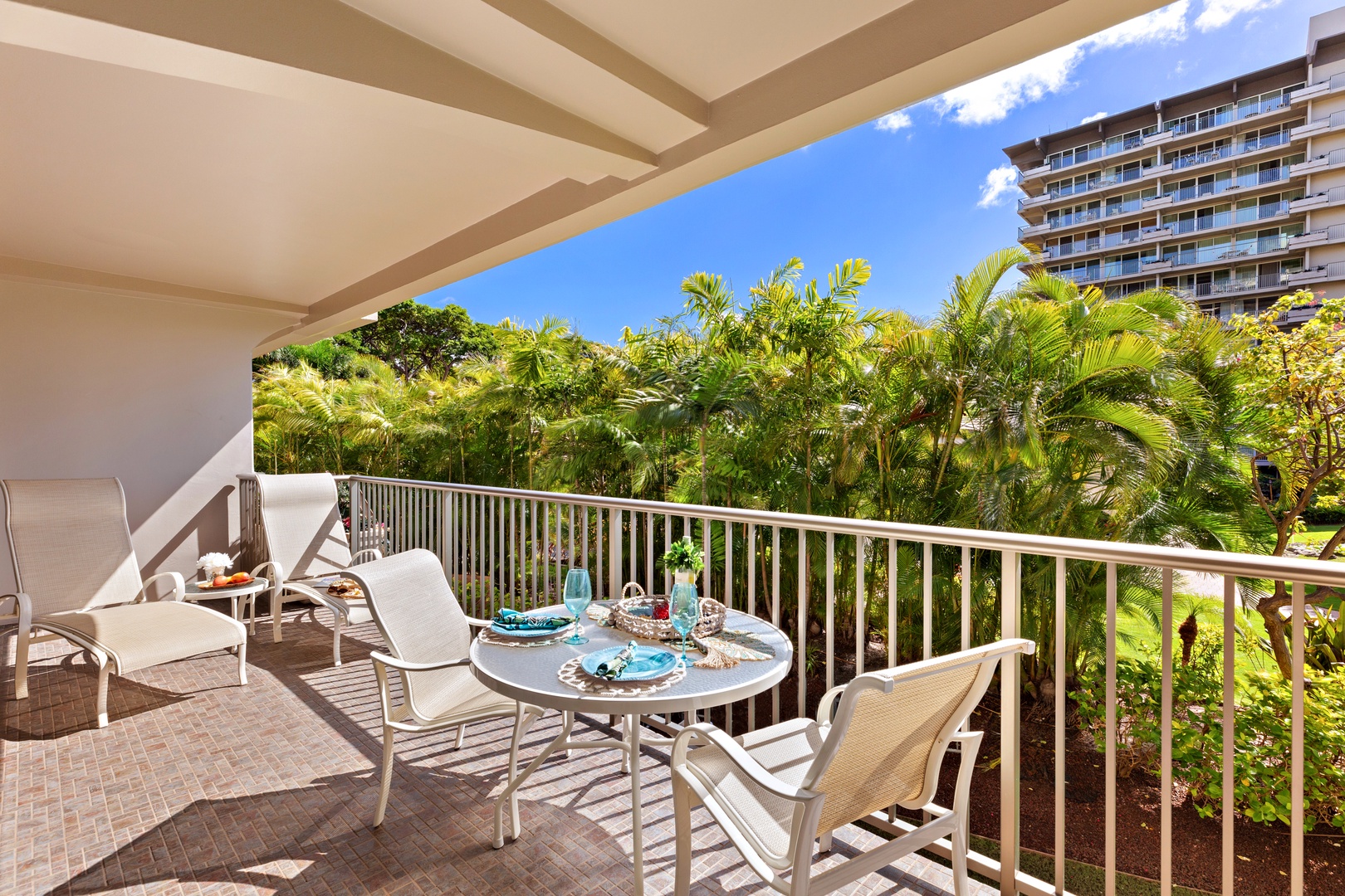 Expansive balcony with panoramic views of lush landscapes and distant mountains, featuring comfortable seating for relaxation.