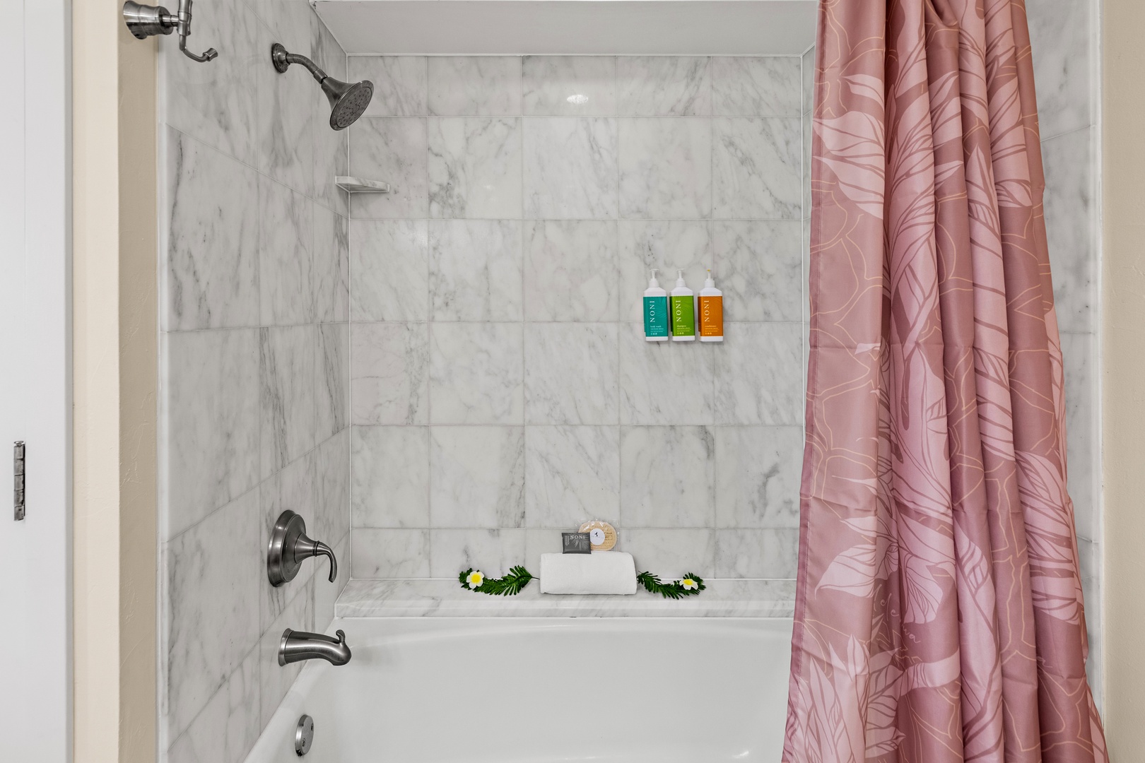 Pamper yourself in this elegant marble shower-tub combo, complete with luxurious toiletries and soft towels for your comfort.