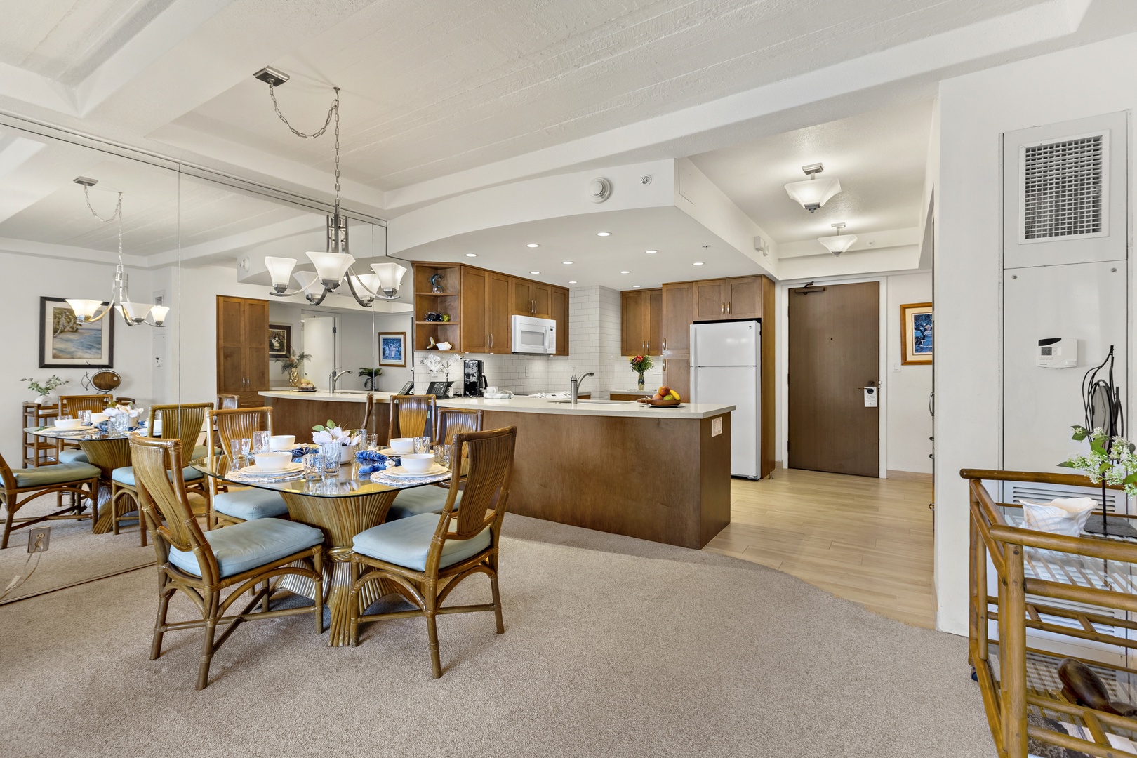 Welcoming dining area adjacent to a fully equipped kitchen, featuring bar seating, warm wood cabinetry, and an open layout ideal for gatherings.
