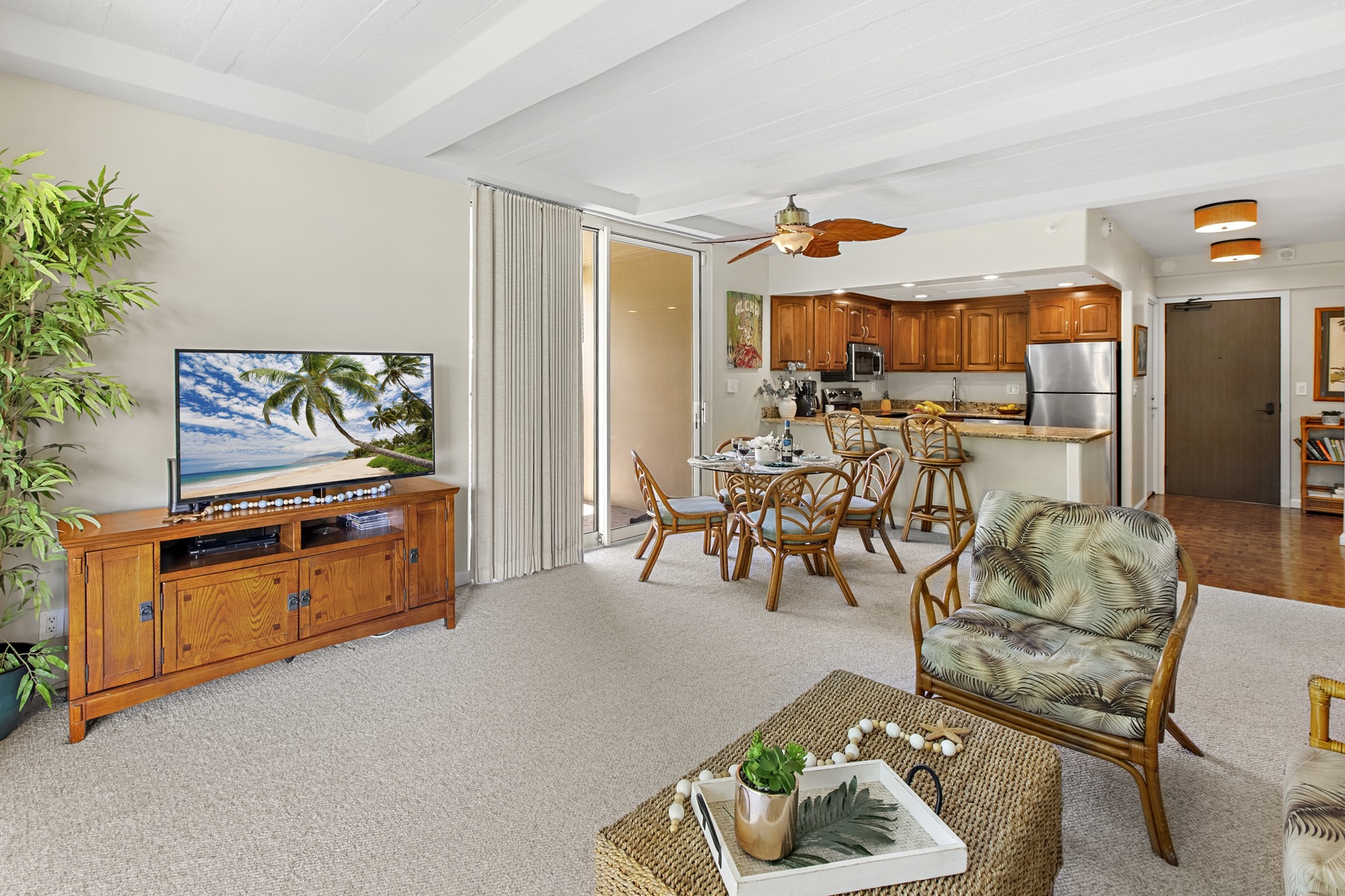 Unwind in your tropical-themed living space with bamboo furnishings, a full kitchen, and entertainment center for perfect island relaxation.