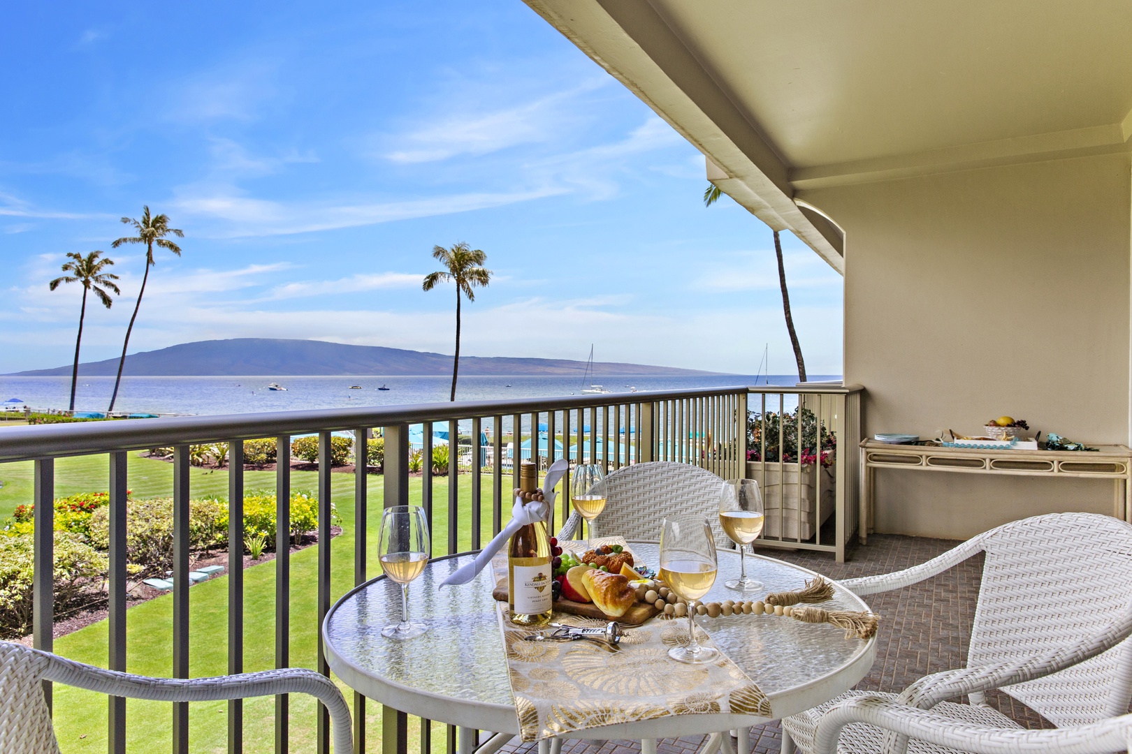 Sip wine on your private balcony while soaking up stunning ocean views framed by swaying palms and distant mountains.