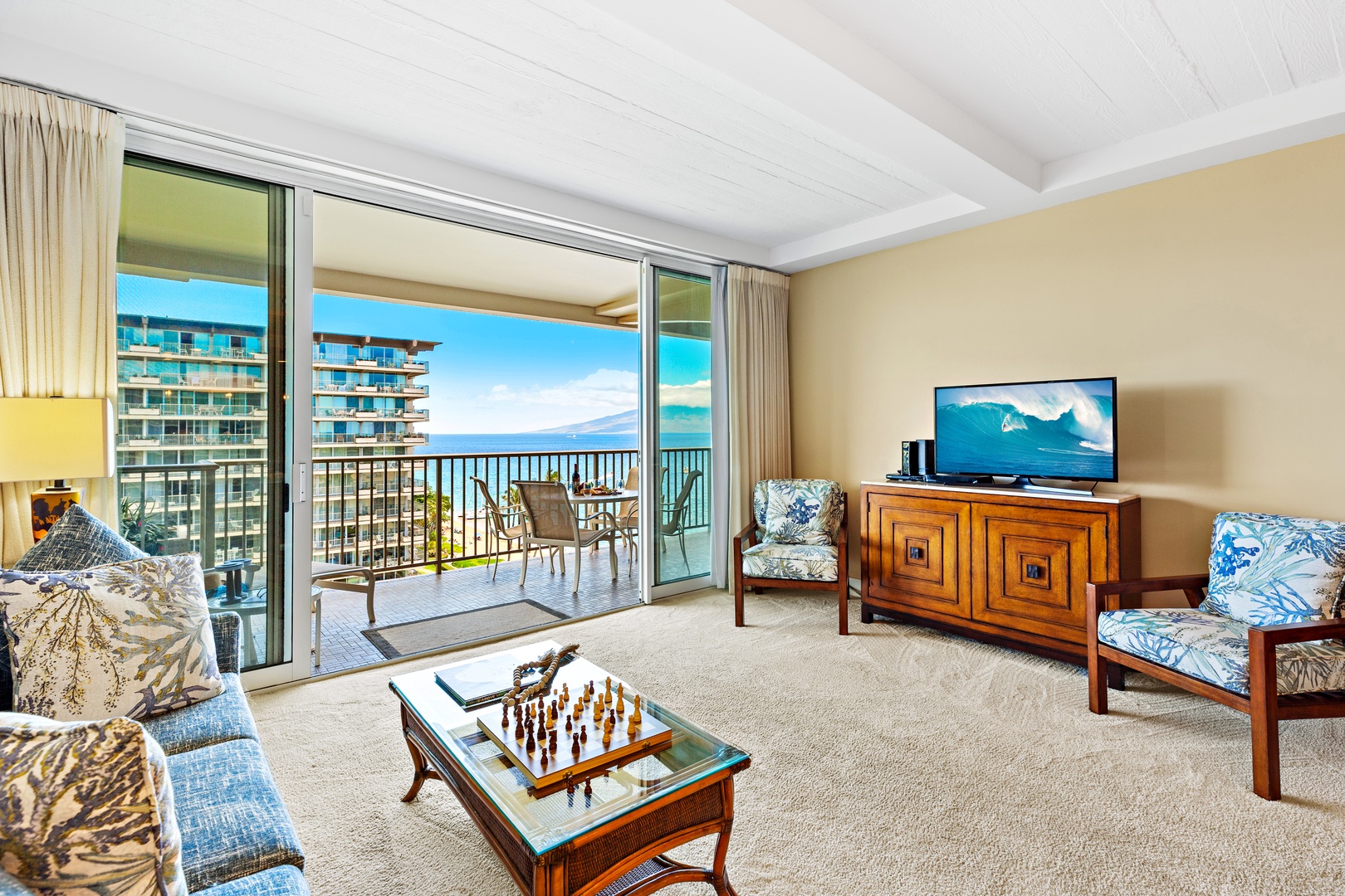 Your living room flows seamlessly to a furnished balcony with stunning ocean and island views, creating the perfect backdrop for your Hawaiian escape.