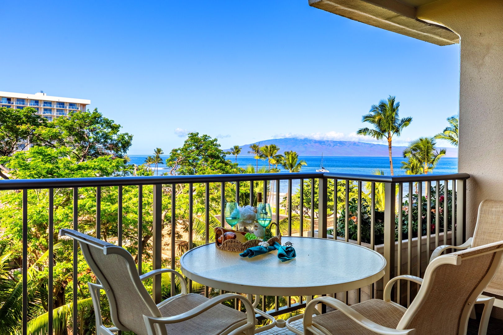 Stunning ocean views with tropical palm trees and distant island vistas await from this private lanai, perfect for peaceful mornings or sunset cocktails overlooking paradise.