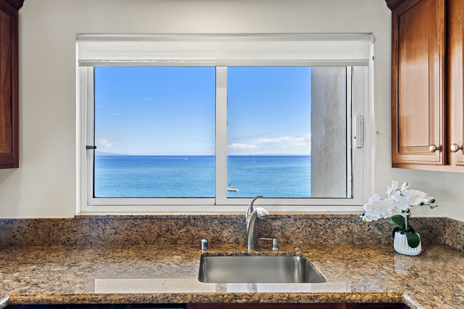 Imagine preparing meals with a stunning sea view as your backdrop—this kitchen's granite counters and ocean-facing window make every moment memorable.