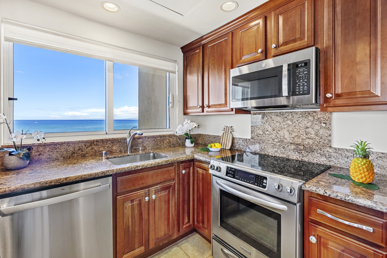 Cook your favorite meals in this fully equipped kitchen with granite counters, stainless steel appliances, and stunning ocean views through the window—your perfect home away from home.