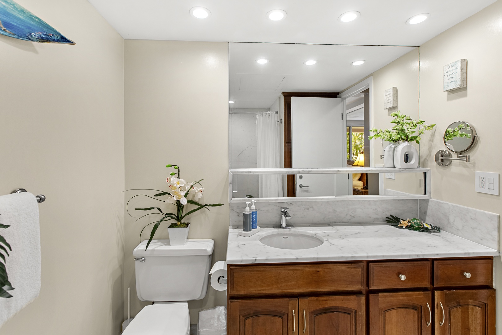 Refresh in your private marble-topped bathroom with elegant wood cabinetry, bright lighting, and thoughtful touches like fresh orchids.