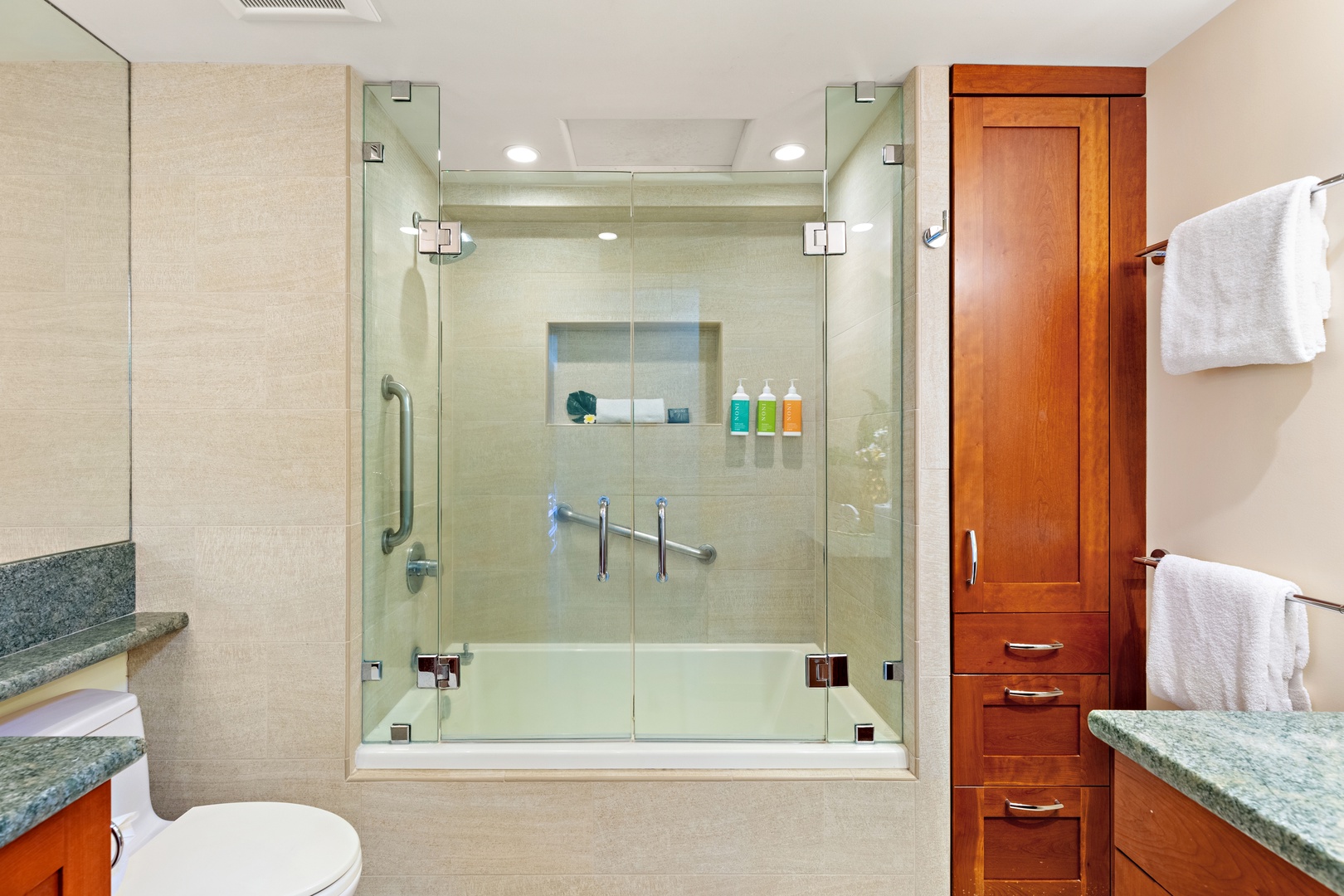 Unwind in your modern, thoughtfully designed bathroom featuring a spacious walk-in shower with premium amenities and plush, freshly folded towels waiting for you.