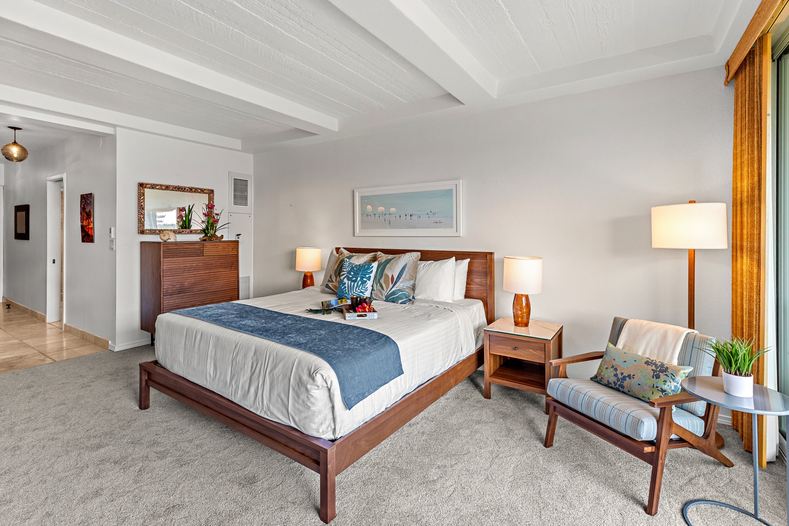 Sink into your plush bed beneath soaring beamed ceilings, where coastal blues and warm wood tones create a serene retreat for restful nights.