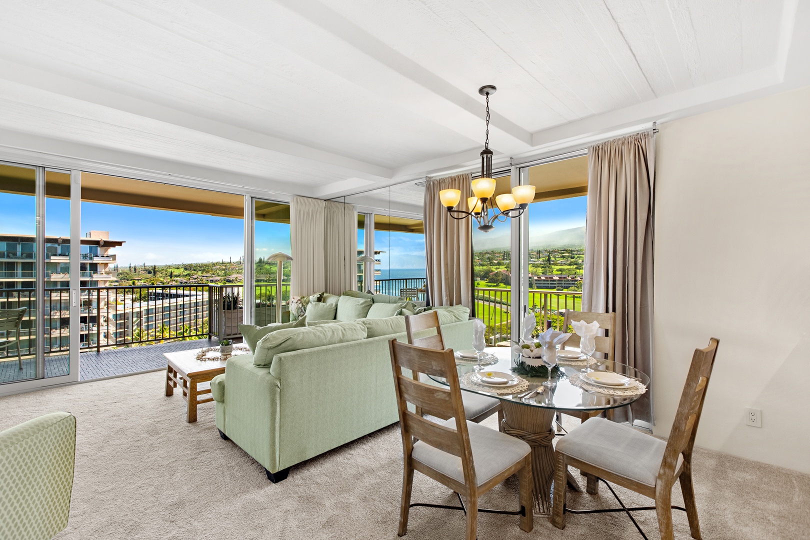 Picture yourself unwinding in this bright, airy retreat where ocean breezes drift through open lanai doors, and your breakfast table offers breathtaking views of lush greenery and sparkling blue waters beyond.