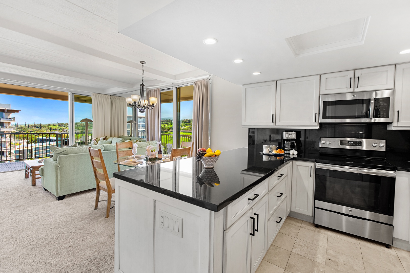 Step into your bright, open living space where polished countertops and modern appliances make cooking effortless, while sunlit views stretch across lush greenery just beyond your private balcony.