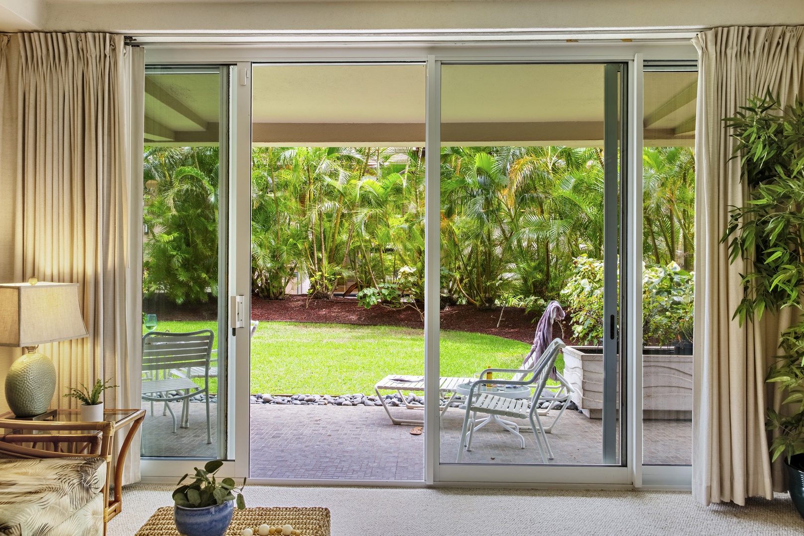 Step through sliding doors onto your private patio where tropical gardens create a peaceful retreat for morning coffee or evening relaxation.