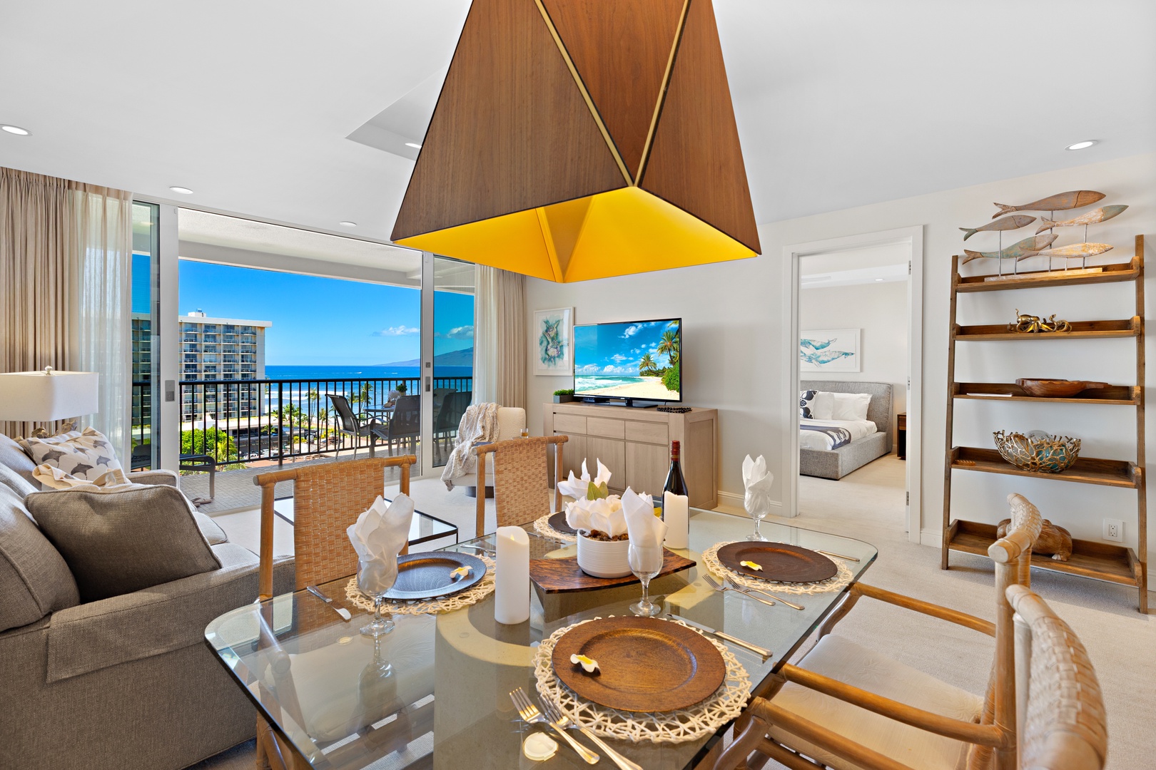Your stunning oceanfront retreat features an open living space with floor-to-ceiling windows framing endless blue water views. Relax in coastal-inspired comfort with beach décor and direct balcony access to sea breezes.