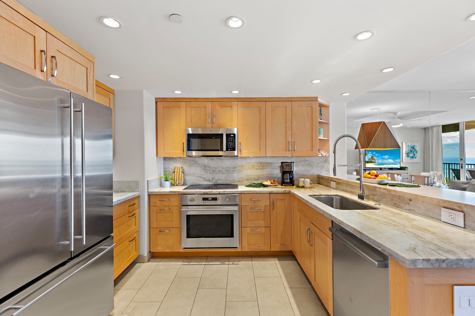 Your gourmet kitchen with granite counters and stainless appliances opens to a stunning ocean view—prepare meals and gaze at paradise.