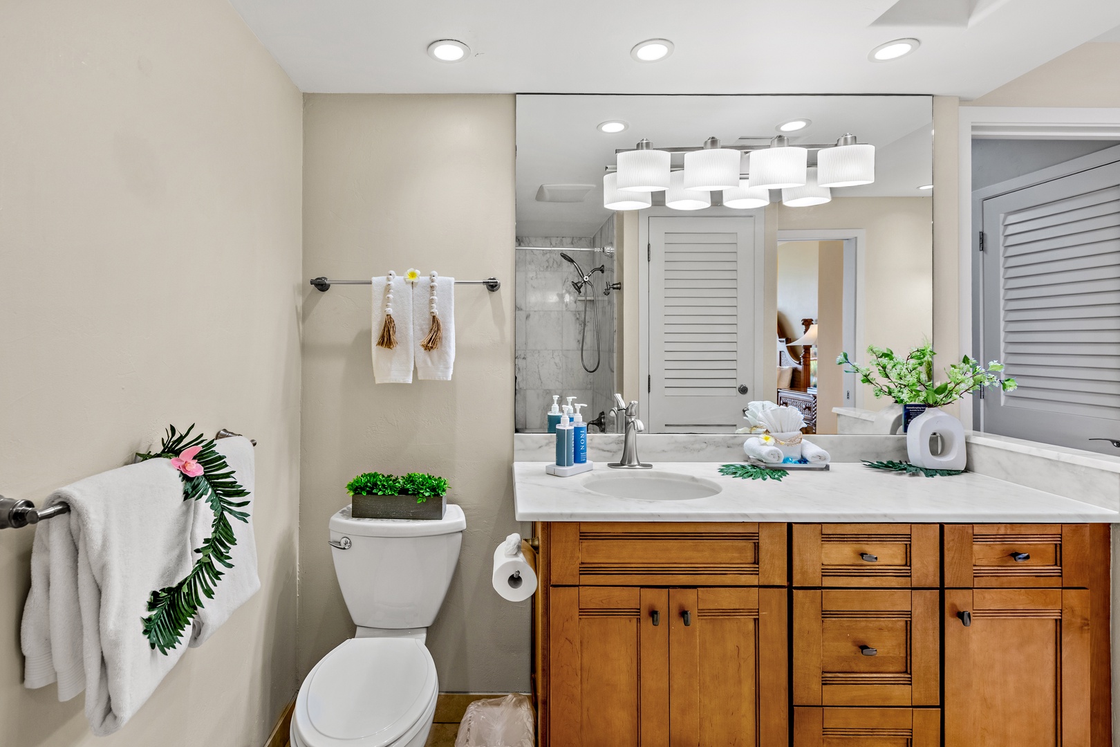 Step into your spa-like bathroom sanctuary with warm wood vanity, marble shower, and thoughtful amenities for your comfort.