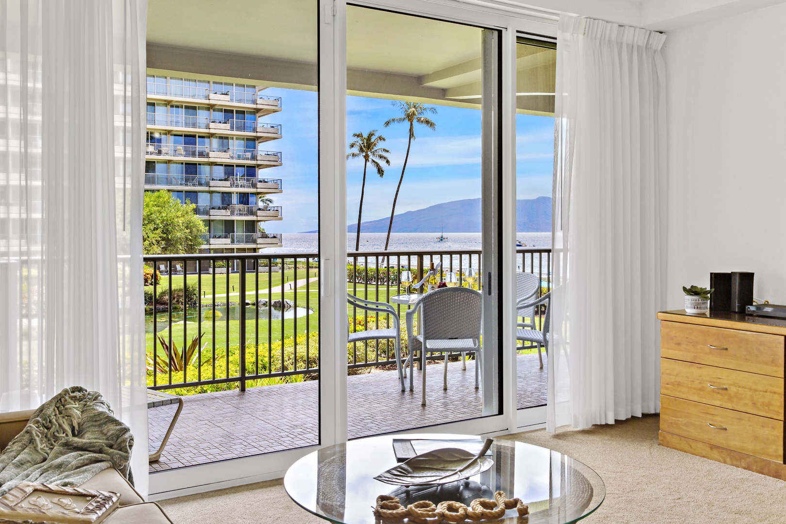 Unwind in your bright living space with stunning ocean and mountain views through floor-to-ceiling windows, opening to your private balcony paradise.