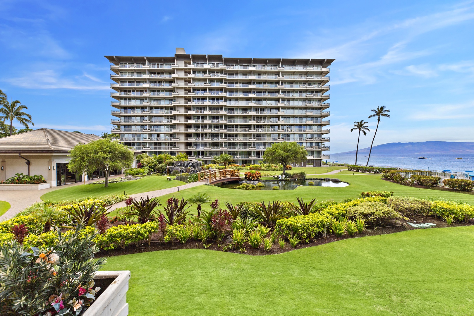 Beachfront resort property with manicured gardens, tropical landscaping, and ocean views on a pristine Hawaiian coastline.