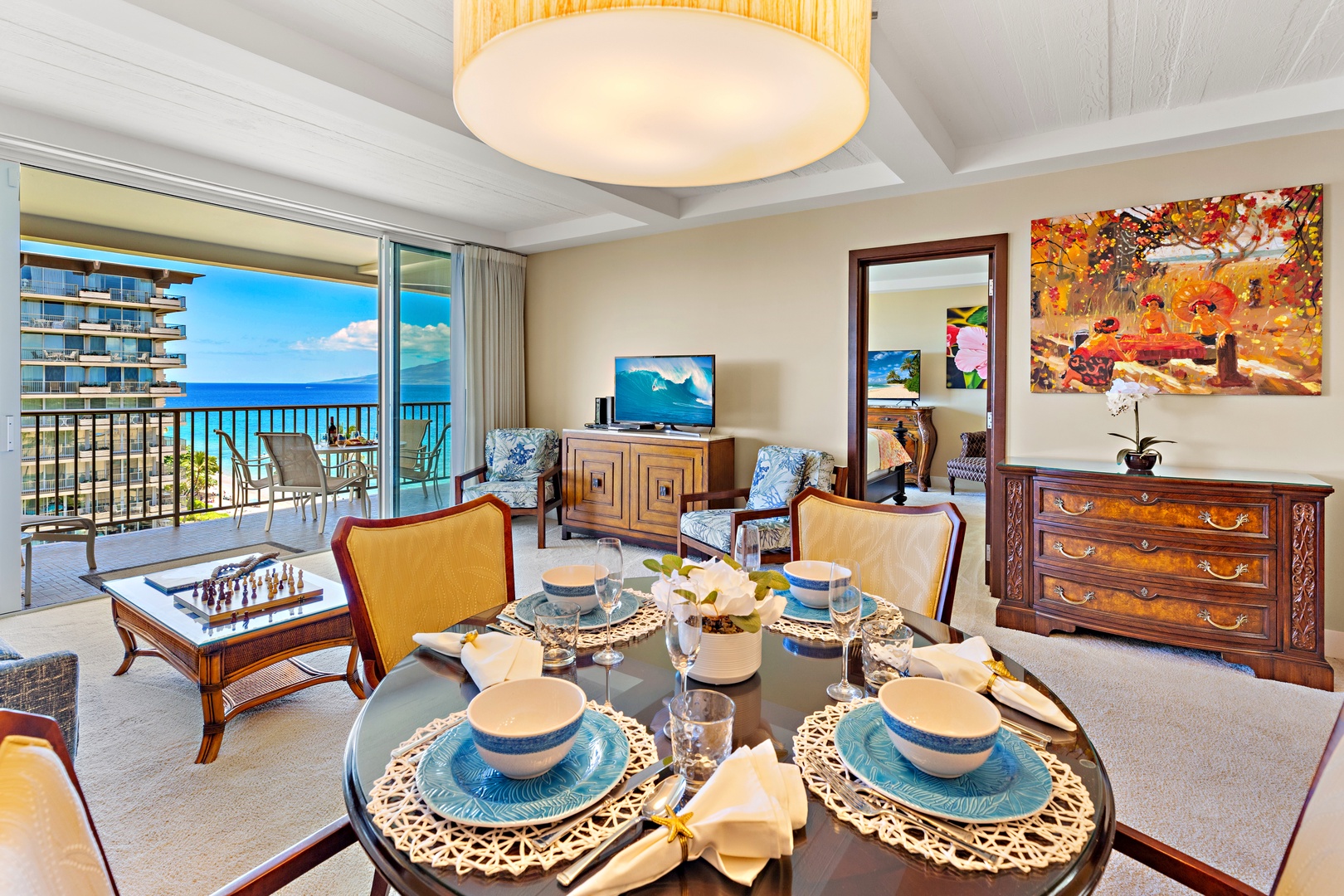 Settle into your bright, inviting living space where rich wood furnishings and colorful artwork create a warm atmosphere. Step onto your private balcony and take in stunning ocean views that stretch to the horizon.