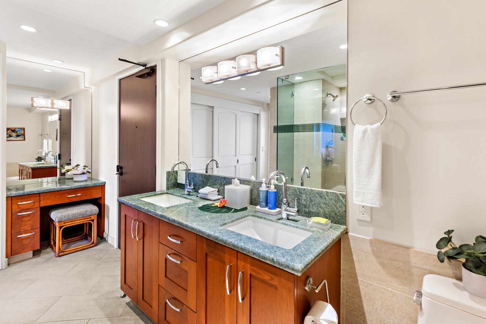 Your spacious bathroom features dual vanities with elegant granite countertops, warm wood cabinetry, and fresh linens awaiting your arrival—perfect for unwinding after a day of adventure.