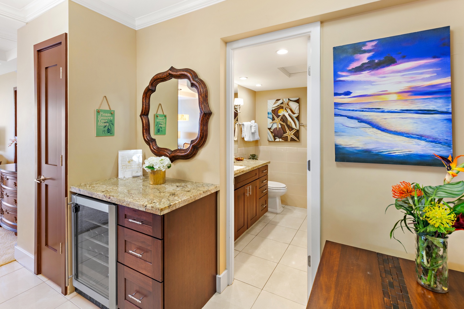 Step into your private retreat with a welcoming wet bar and beautifully appointed bathroom. Elegant coastal artwork and fresh florals create a warm, inviting atmosphere you'll love coming home to.